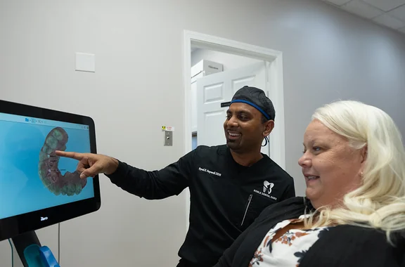 Dr. Sayeedi reviewing a 3D dental scan with a patient