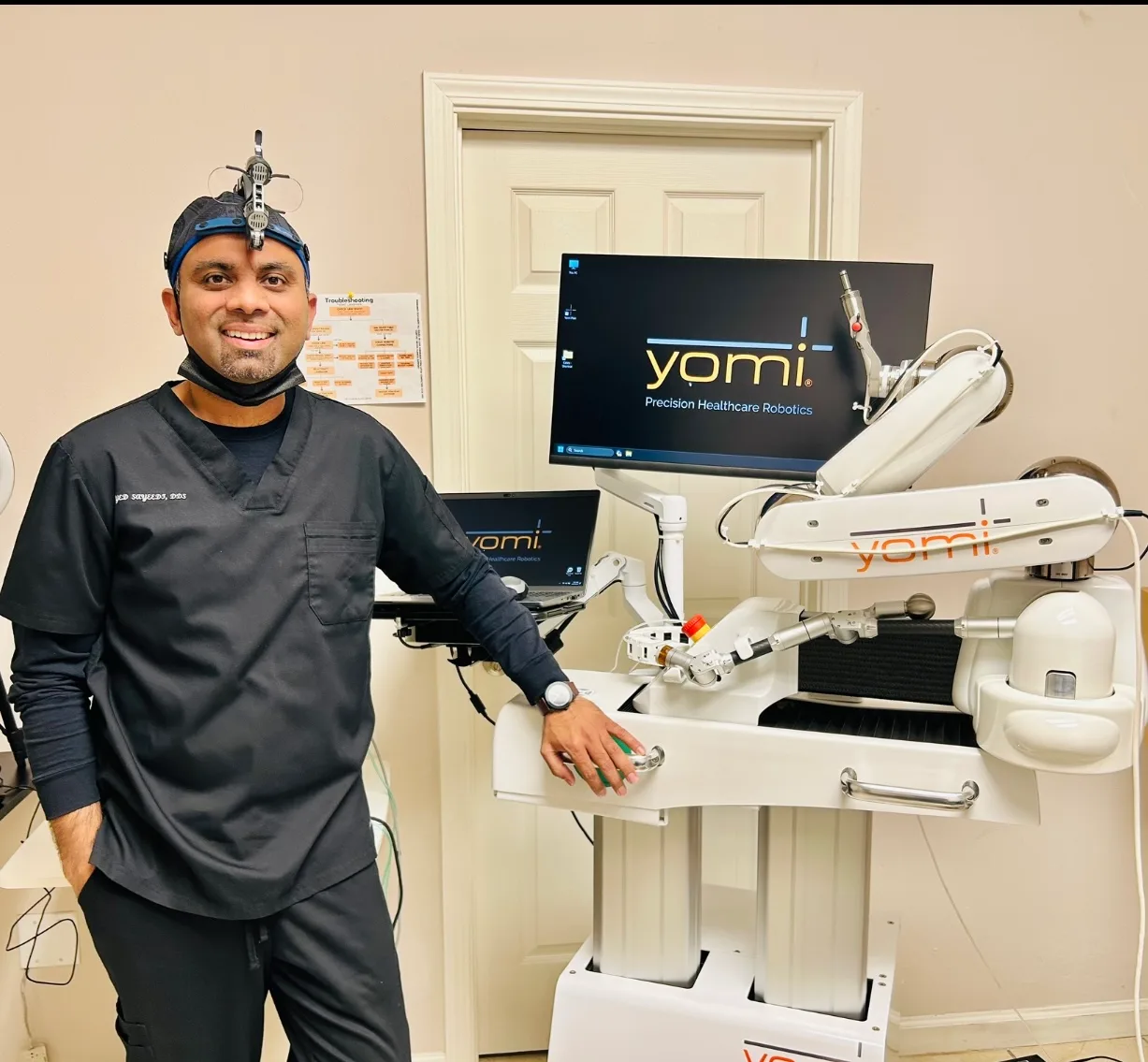 Dr. Sayeedi beside Yomi robotic implant guidance equipment at Noble Dental Care